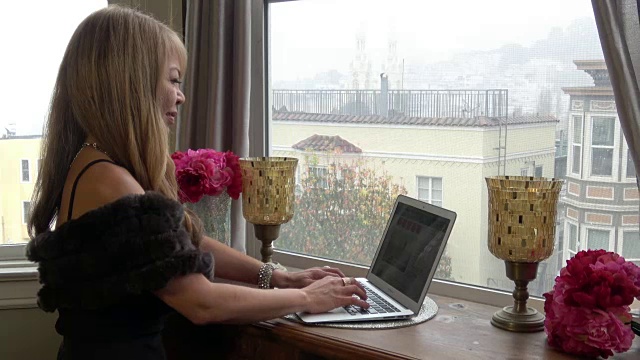 年轻女性在家庭办公室的移动网络与城市景观视频下载