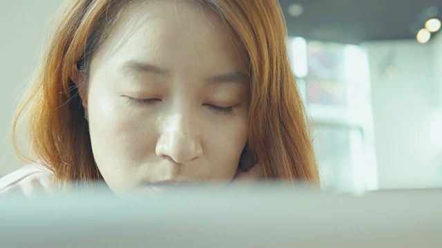 年轻的亚洲女性使用笔记本电脑视频下载