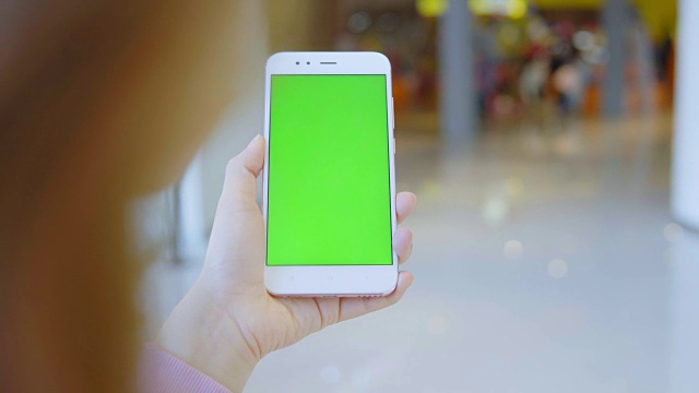 一名女子在街上用绿屏智能手机视频素材