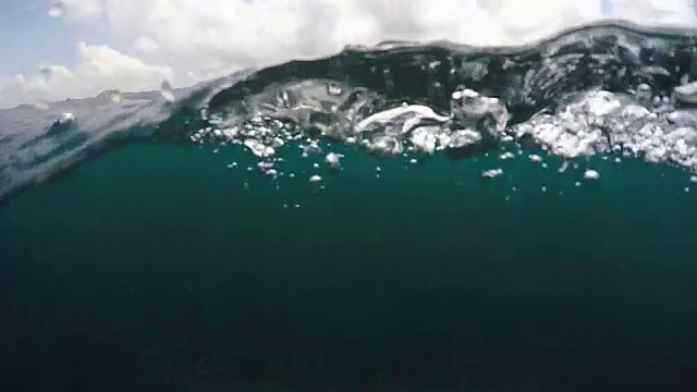 一个冲浪者在他的冲浪板上冲浪。——慢动作视频素材