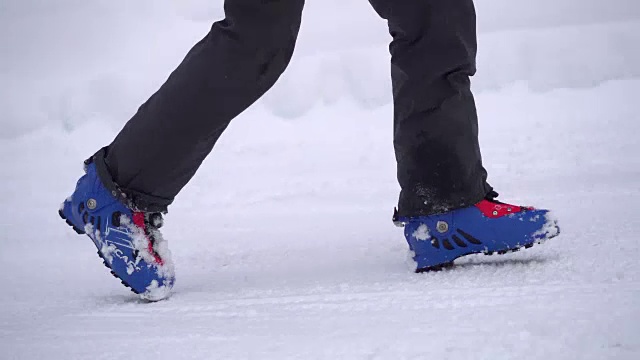 穿着滑雪靴在雪地上行走视频素材