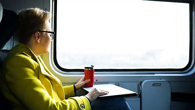 女人正坐在火车里，拿着笔记本电脑视频素材