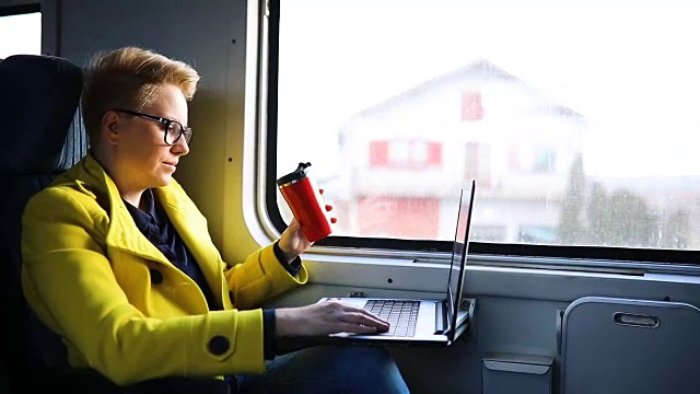 女人正坐在火车里，拿着笔记本电脑视频素材