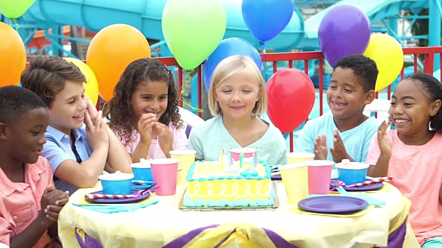 孩子们在生日聚会上吹灭蛋糕上的蜡烛视频素材