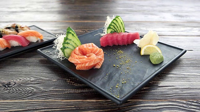 手握寿司和生鱼片，木桌。视频素材
