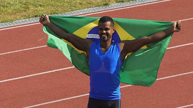 肌肉发达的巴西国家队运动员展示他的旗帜庆祝胜利视频下载
