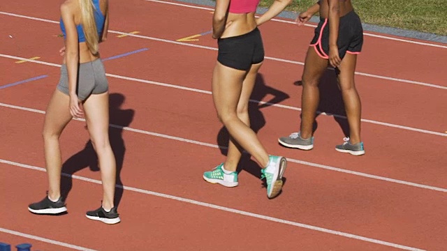 年轻的女运动员在马拉松后的跑道上行走，运动，慢动作视频下载