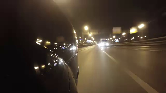 快速城市驾驶夜间道路POV时间推移左侧的汽车。低角度后视图视频素材