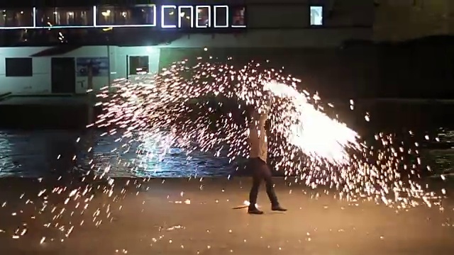 艺术家杂耍与两个燃烧的poi的火表演。视频素材