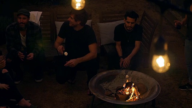 在夏天的晚上，一群朋友在烤棉花糖视频素材