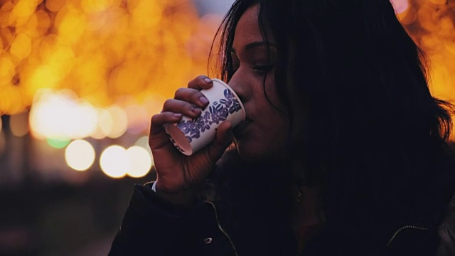 美丽的多民族女子在夜城喝茶视频素材