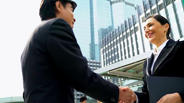 两个人的商业握手，表明他们同意在他们的公司/公司/企业之间签署协议或合同。视频素材