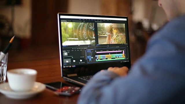 自由视频编辑在笔记本电脑与电影编辑软件工作。视频摄像师、视频博主或编辑视频的博主摄像师。跟踪显示镜头视频下载