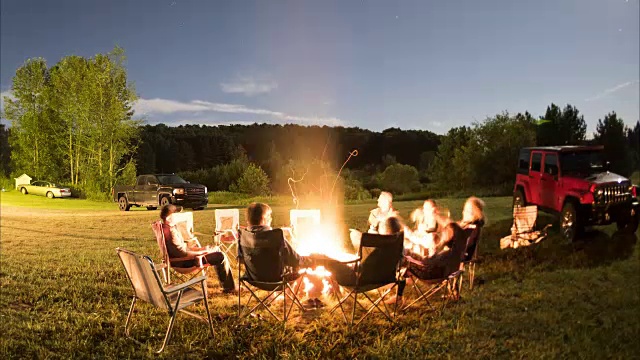 在一个美丽的夏夜，一群人围着篝火视频素材