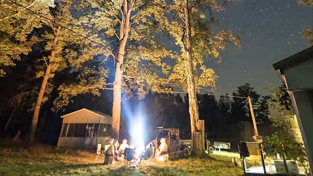 在一个美丽的夏夜，一群人围坐在篝火旁视频素材