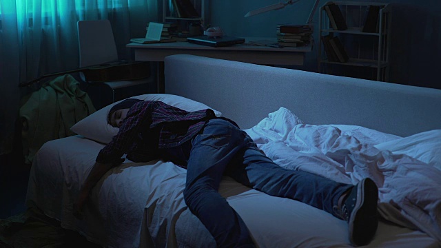 男少年在晚上聚会后穿着睡衣睡在沙发上，困难的年龄视频素材
