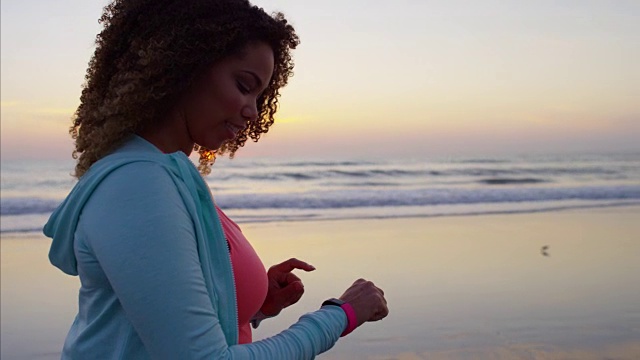 日出时分在海滩上散步的非裔美国女性视频素材