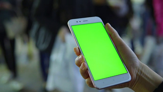 一名女子在街上用绿屏智能手机视频素材