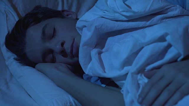 男性青少年夜间健康睡眠，儿童面部特写，放松视频素材