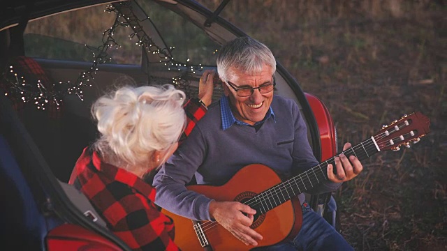 浪漫的老男人为漂亮的老女人弹吉他视频素材
