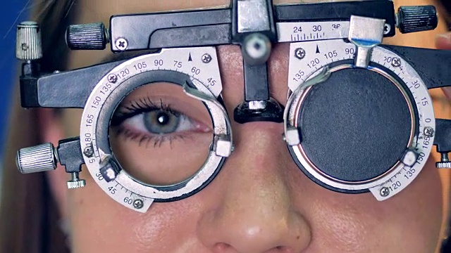 在光学试验框架后面的一个女人眼睛的特写。视频下载