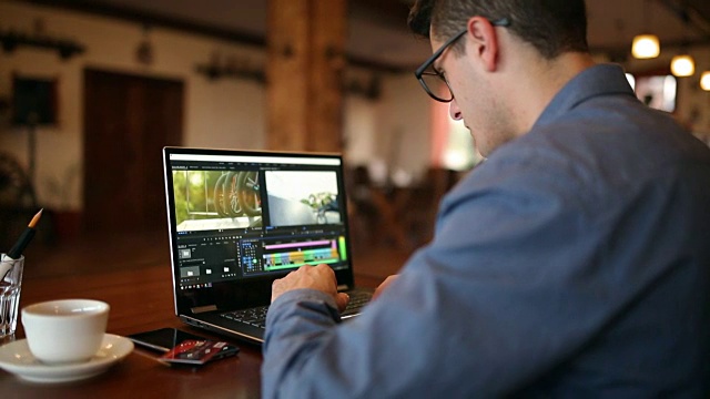自由视频编辑在笔记本电脑与电影编辑软件工作。视频摄像师、视频博主或编辑视频的博主摄像师。跟踪显示镜头视频素材
