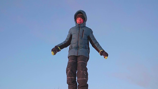 那家伙站在雪坡上，背靠天空。下雪的冬天的风景。在户外运动视频下载