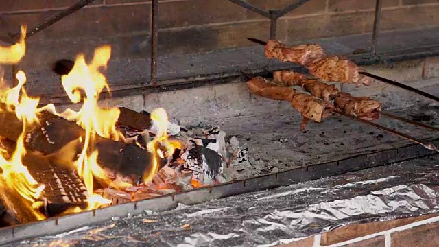 串着烤肉串的烤肉串正被放到烤架上，在大火旁烤着吃视频素材
