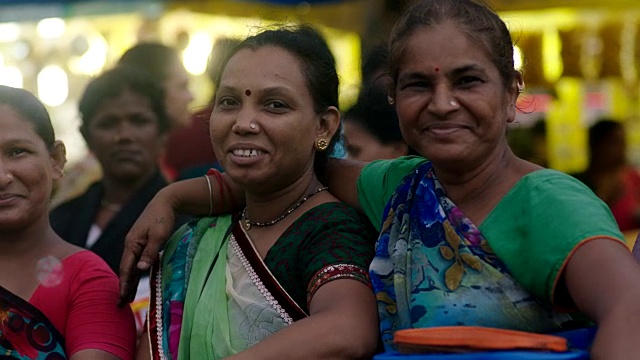 在繁忙的孟买市场，一群妇女对着镜头大笑和微笑。视频素材