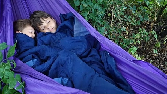 两个男孩一起睡在吊床上视频素材