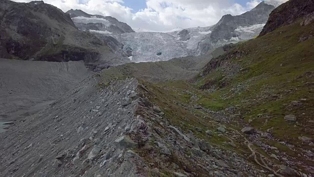 反向无人机拍摄的女子在瑞士的山脊上徒步旅行视频素材