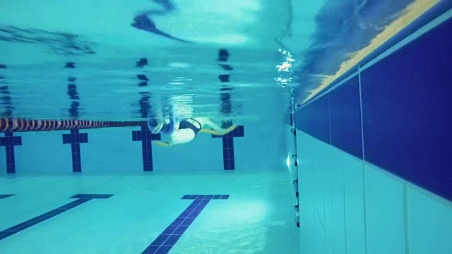 老年妇女用特殊的设备在游泳池游泳——水下视频下载