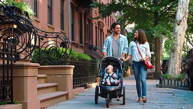 一对夫妇走在街上，婴儿在婴儿车里，特写视频素材