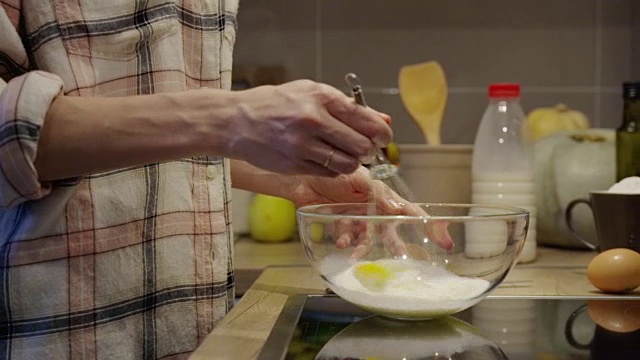 一个女人在厨房里用玻璃碗摇晃着打蛋器视频素材