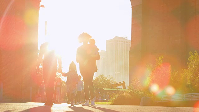 年轻的一家人在曼哈顿的一座桥下散步，背光照明视频素材