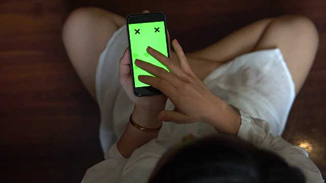 少女在家里使用绿色屏幕的智能手机视频素材