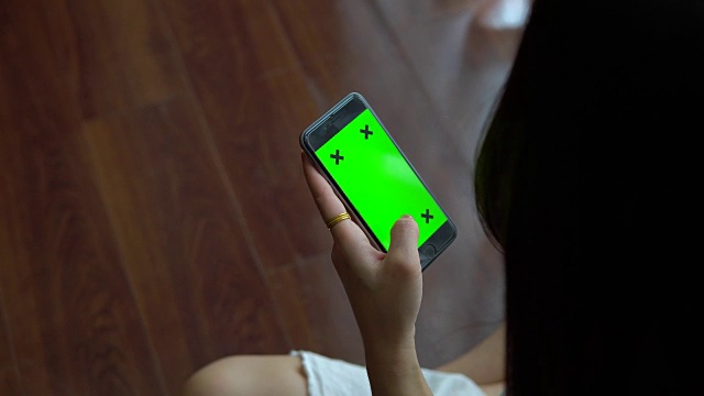 少女在家里使用绿色屏幕的智能手机视频素材