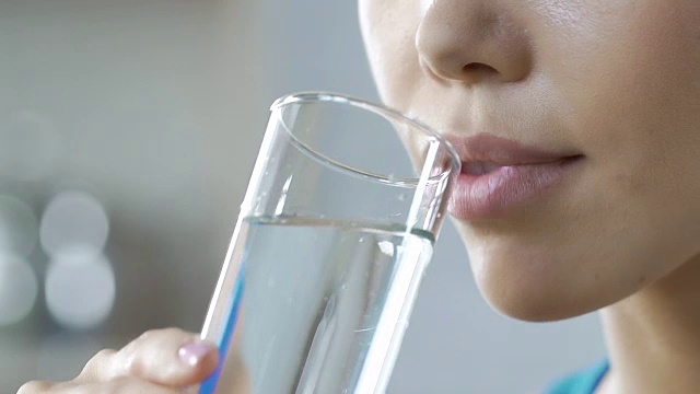 女孩喝干净新鲜的矿泉水杯，水平衡身体，水合作用视频素材