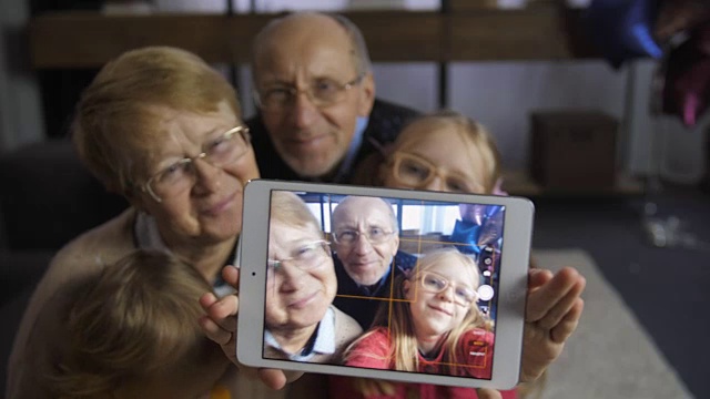 女孩在用触控板和祖父母自拍视频下载