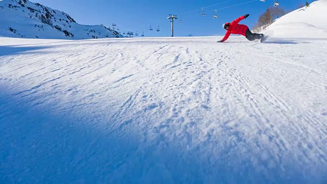 滑雪板在滑雪坡上做一个大转弯，背景是滑雪缆车视频素材