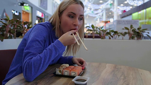 特写小女孩吃寿司用筷子在一家日本餐厅视频素材