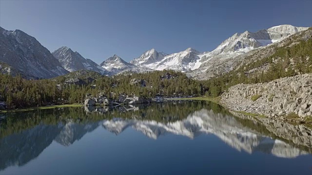 空中侧扫雪山山谷与湖反射-因约国家森林，小湖山谷小径(宝石湖)，主教，加州视频下载
