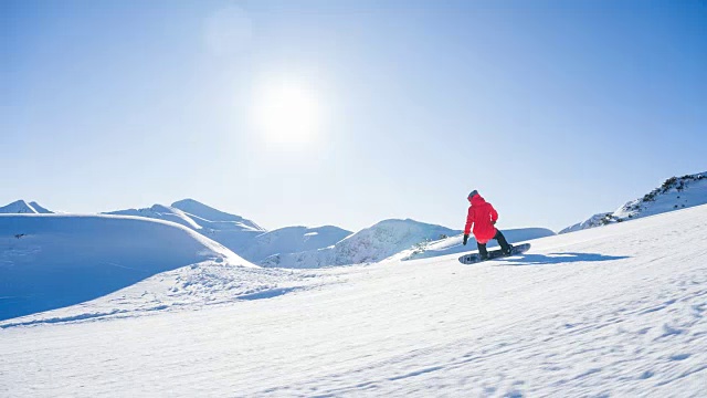 在一个阳光明媚的日子里，在一座雪山上滑雪视频素材