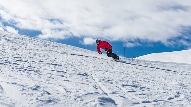 在一个阳光明媚的日子里，滑雪者从滑雪坡上滑下来，将雪喷向摄像机视频下载