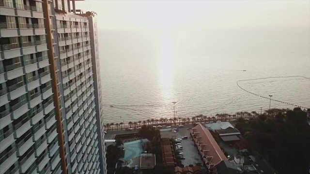 海滩上美丽的日落。视频。酒店建筑与美丽的日落。黄昏时分，城市和大海中的黎明视频下载