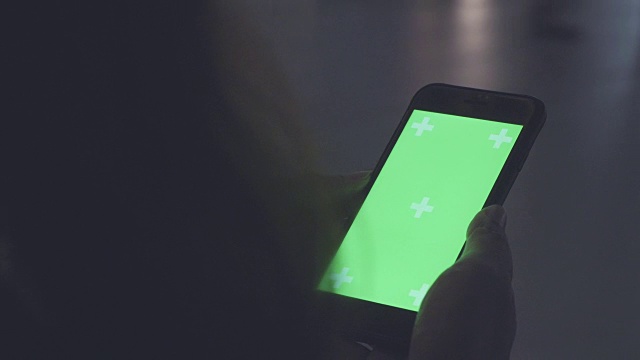 一个女人在看绿色屏幕的智能手机视频素材