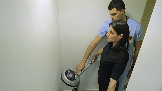 一个女人用现代医疗设备体检。医生调整设备视频素材