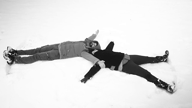 一对夫妇在雪中做天使形状视频下载