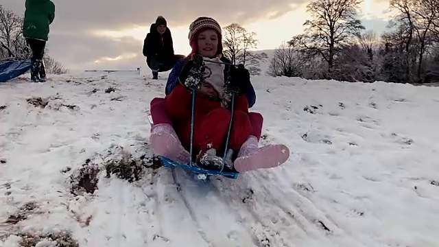 圣诞假期，姐妹们在雪山上共用一辆雪橇视频素材