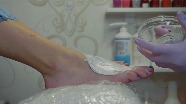 美容师在美容院做足底按摩前涂抹保湿霜视频素材
